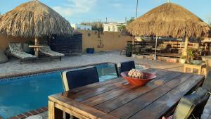 a wooden table and chairs next to a swimming pool at Fuego Mio Bed & Breakfast in Santa Cruz