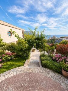 a garden with a stone walkway and flowers at Vila Angel in Bečići