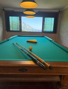 a pool table with cue balls and bats on it at Vila Angel in Bečići