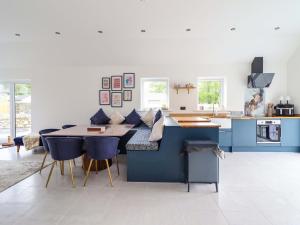 a kitchen with a blue island with a table at Kingfisher in Talybont