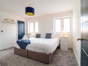 a bedroom with a bed and two windows at Kingfisher in Talybont