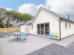 a white house with a table and chairs on a patio at Kingfisher in Talybont