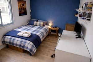 a bedroom with a bed and a desk with a computer at Le chalet in Oullins
