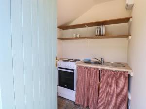 a kitchen with a sink and a stove at The Bowtop Gypsy Caravan in Eye +8 photos