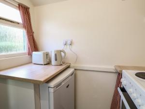 a kitchen with a wooden counter top and a window at The Bowtop Gypsy Caravan in Eye