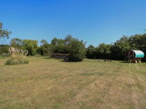 a large field with a barrel in the middle of it at The Bowtop Gypsy Caravan in Eye