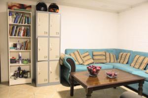 a living room with a blue couch and a table at Backpackers House - Near The Airport in Santiago