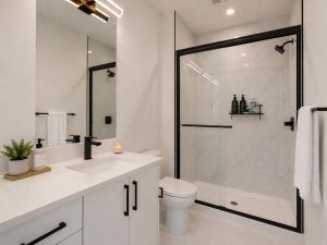 a white bathroom with a shower and a toilet at Emerald - 10mins from Stampede Park in Calgary +90 photos