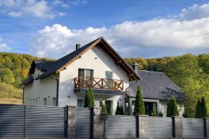 a white house with a fence in front of it at The Nest Apartment in Sovata
