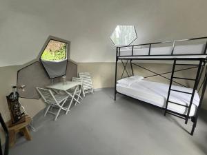 a bedroom with a bunk bed and a table and chairs at triDOMESFRANCE in Saverne