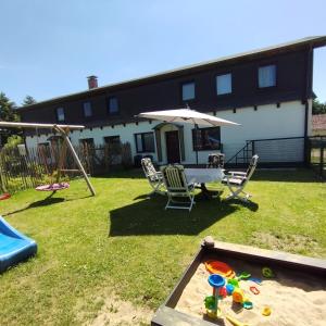 a backyard with a table and chairs and an umbrella at Ferienhaus Feldbrise in Gottesgabe