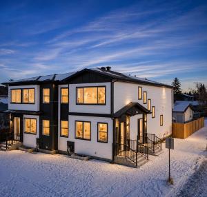 a house in the snow with its lights on at Emerald - 10mins from Stampede Park in Calgary