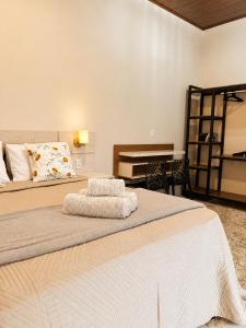 a bedroom with a large bed and a piano at Flats Araras do Vale in Colinas Do Sul +35 photos