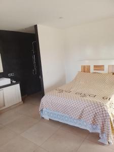 a bedroom with a bed in a white room at Les chambres de la mangrove in Somone
