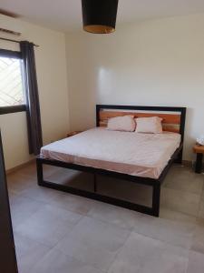 a bedroom with a bed in a room at Les chambres de la mangrove in Somone