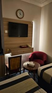 a hotel room with a tv and a bed and a chair at فندق سكب الأصيل in An Naqāʼ
