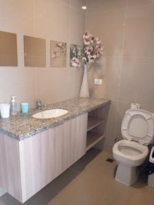 a bathroom with a sink and a toilet and a vase with flowers at Vista Urbana Atlantis in Santa Cruz de la Sierra