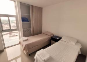 a small room with two beds and a window at Vista Urbana Atlantis in Santa Cruz de la Sierra +5 photos