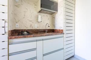 a kitchen with white cabinets and a sink at Flat Sudoeste Vienna by CentoEdez in Brasília +43 photos