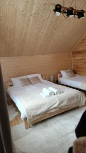 two beds in a room with a wooden ceiling at Lipowe Love in Lipowa