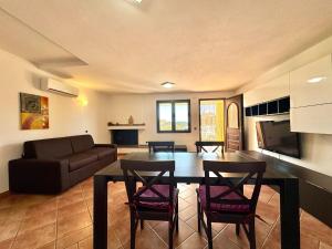 a living room with a table and chairs and a couch at Orange House in Bari Sardo +17 photos
