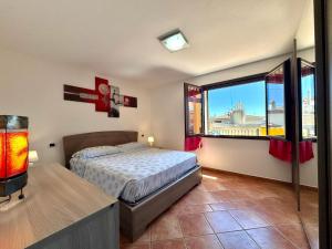 a bedroom with a bed and a large window at Orange House in Bari Sardo