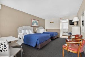 a hotel room with two beds and a table and chairs at Starfire Motel in Wildwood +35 photos