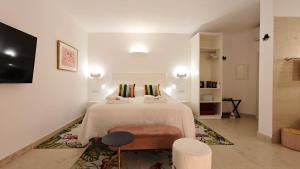 a white bedroom with a bed and a chair at The White Knight Premium Boutique Hotel in Għajnsielem