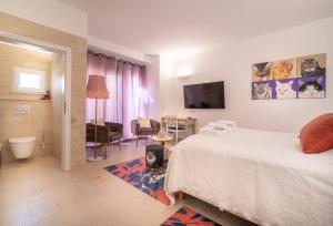 a bedroom with a bed and a living room at The White Knight Premium Boutique Hotel in Għajnsielem +156 photos