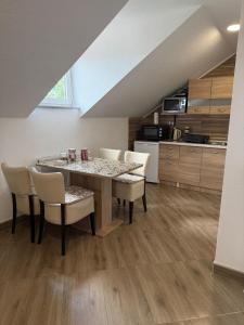 a kitchen and dining room with a table and chairs at Apartment Slap in Rakovica