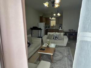 a living room with a white couch and a table at Gorenje apartment in Fier