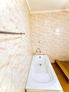 a white bath tub in a bathroom with marble walls at Sea-Point Homes in Maiyegun
