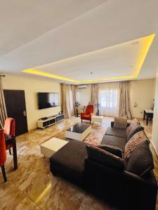 a living room with a couch and a flat screen tv at Sea-Point Homes in Maiyegun