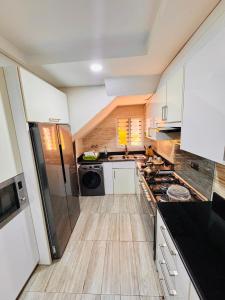 a kitchen with white cabinets and a stove top oven at Sea-Point Homes in Maiyegun +15 photos