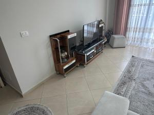 a living room with a television and a tiled floor at Gorenje apartment in Fier