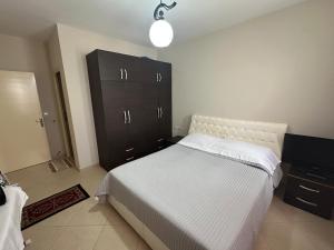 a bedroom with a bed and a black cabinet at Gorenje apartment in Fier
