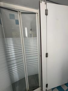 due porte scorrevoli in vetro in una stanza di 70's Hostel a Ericeira