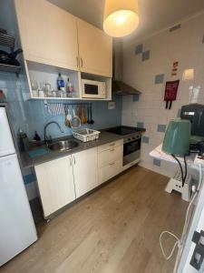 una cucina con lavello e fornelli forno a legna di 70's Hostel a Ericeira