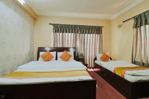 a bedroom with two beds and a window at Hotel Lekali Homes in Kathmandu