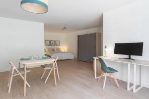 a room with a desk and a bed with a television at Villa Anita in Chevreuse