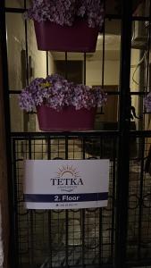 a sign for a flower shop with purple flowers on a rack at Tetka Guest House in Kotor