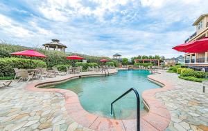 a swimming pool with tables and umbrellas at a resort at Good Trouble - Croatan Surf Club, Ocean View, Indoor and Outdoor Pool, Hot Tub, Pets Ok, YR Flex in Kill Devil Hills