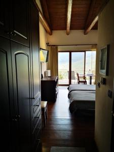 a bedroom with a bed and a desk and a window at Olvios Hotel in Goura +188 photos