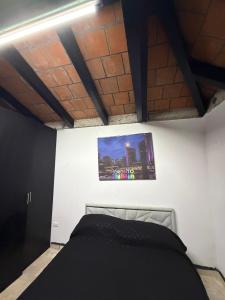a bedroom with a bed and a picture on the wall at Comodo Estudio 8 in El Gallinero