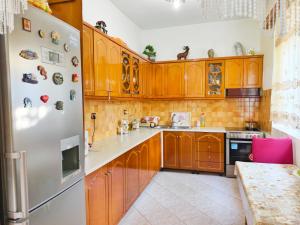 a kitchen with wooden cabinets and a white refrigerator at Shtepi Manuel in Sarandë