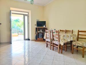 a dining room with a table and chairs and a television at Shtepi Manuel in Sarandë +22 photos