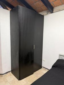 a black cabinet in a room with a bed at Comodo Estudio 8 in El Gallinero +1 photo