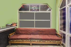 a bench in front of a window with a large window sidx sidx sidx at Super Hotel O by OYO Kavish Residency in Haridwār
