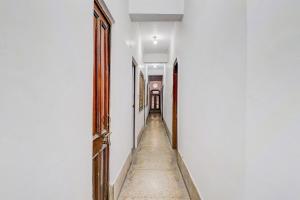 an empty hallway with an open door and a long aisle at Super Hotel O by OYO Kavish Residency in Haridwār