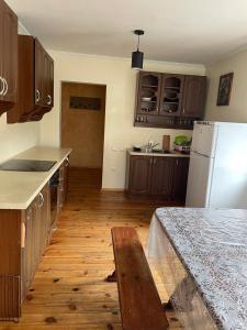a kitchen with wooden floors and a white refrigerator at Ангеліна in Svityazʼ +6 photos